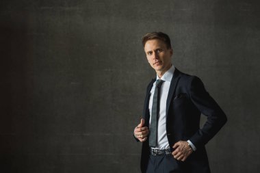 Gri arka plan üzerinde resmi kıyafetli yakışıklı işadamı