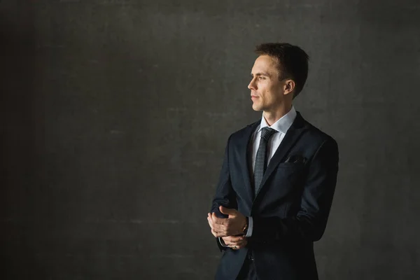 Bonito homem de negócios em terno formal em fundo cinza — Fotografia de Stock