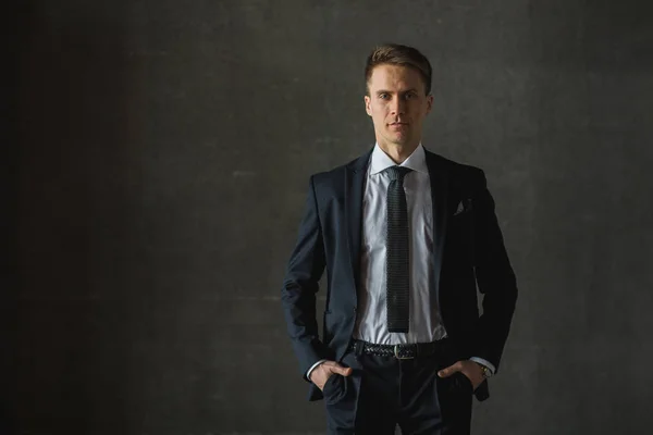 Bonito homem de negócios em terno formal em fundo cinza — Fotografia de Stock
