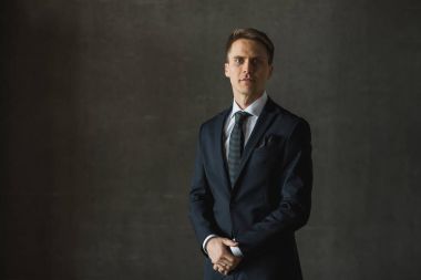 Gri arka plan üzerinde resmi kıyafetli yakışıklı işadamı