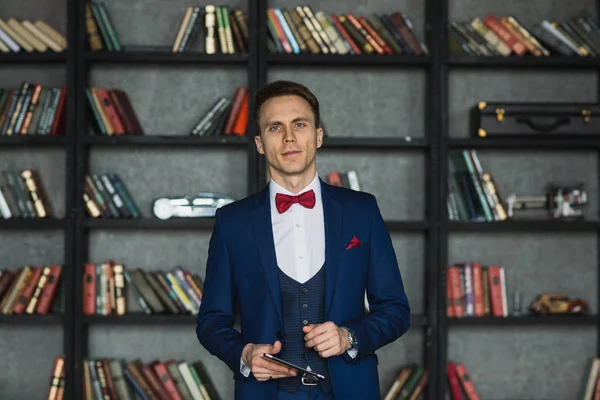 Mladý podnikatel v modrém obleku emocionální pózuje s tabletem — Stock fotografie