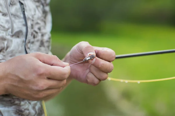 Mano de hombre atando un anzuelo. Ata la plataforma. Enfoque selectivo. Gancho de lazo de cerca. Gancho de pesca de corbata Atar un anzuelo Proceso . — Foto de Stock