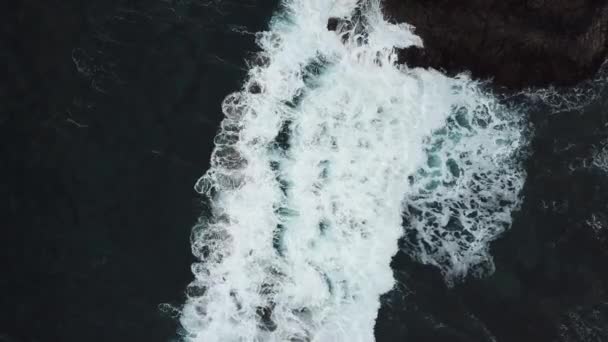 Aérea de las olas del océano lavándose sobre una roca de basalto negro en Tenerife — Vídeo de stock