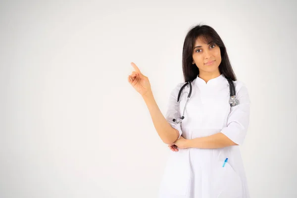 Eine junge Ärztin oder Studentin mit einem Phonendoskop steht auf weißem Hintergrund — Stockfoto
