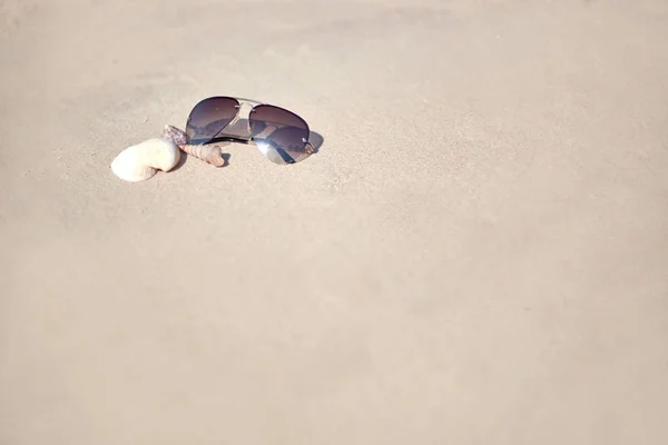 Las gafas de sol en la arena. bandera de vacaciones . — Foto de Stock