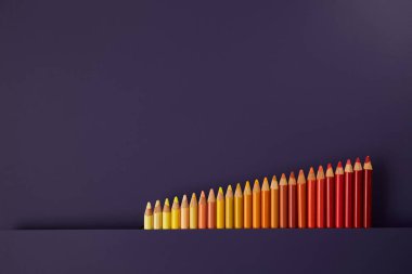 Mor bir arka plan üzerinde renkli kalemler. Güzel kompozisyon