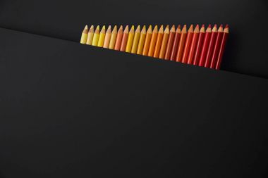 Siyah arkaplanda renkli kalemler