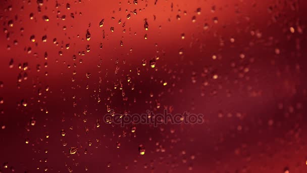 Gotas de lluvia roja en la ventana — Vídeos de Stock