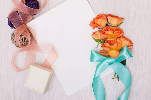 Una maqueta creativa con una tarjeta y una rosa de orang. Hoja vacía de pape — Foto de Stock