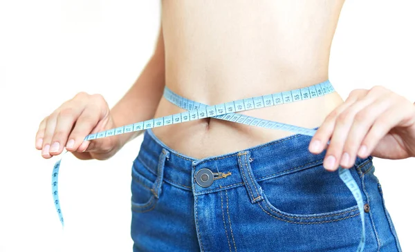 Slender girl measures her waist on a white background — Stock Photo, Image