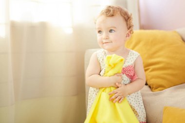 küçük çocuk odasında sarı battaniye ile oynuyor