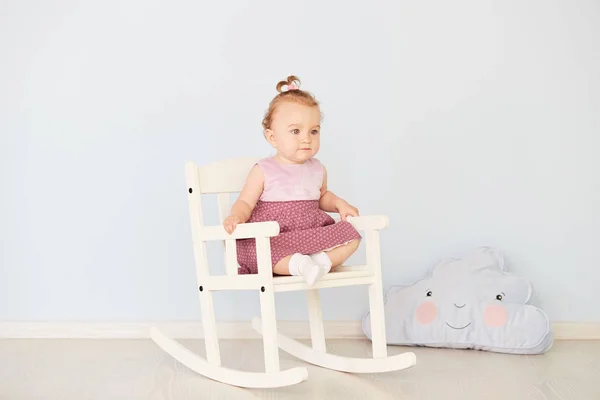 白い椅子に座っているドレスを着た美しい少女 — ストック写真