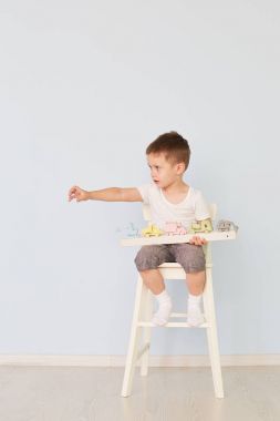 bir çocuk bir makine ile çalış ve sandalyeye oturur