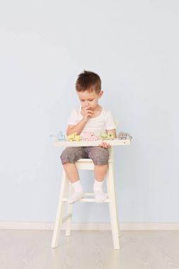 bir çocuk bir makine ile çalış ve sandalyeye oturur