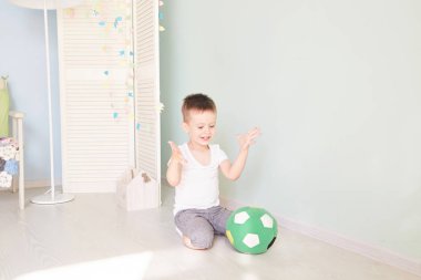 Tam uzunlukta portre olan bir çocuğun evde izole bir futbol topu