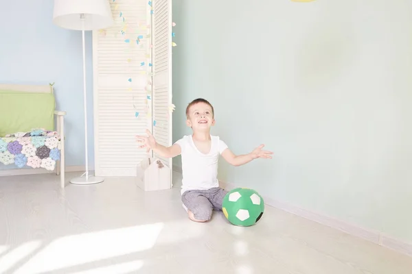 Tam uzunlukta portre olan bir çocuğun evde izole bir futbol topu — Stok fotoğraf
