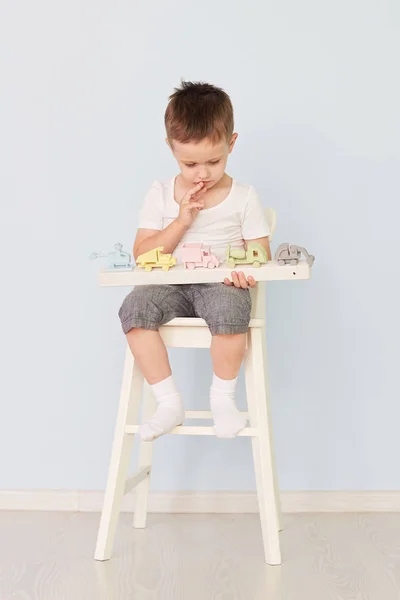 Bir çocuk bir makine ile çalış ve sandalyeye oturur — Stok fotoğraf