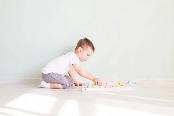 Küçük çocuk evde oyuncak arabayla oynuyor. — Stok fotoğraf