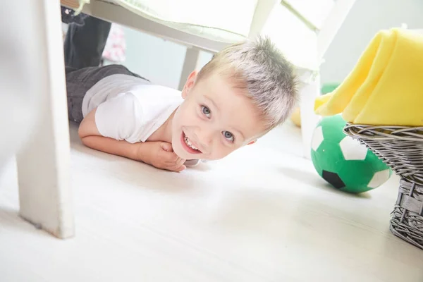 微笑着的小男孩躺在家里的地板上. — 图库照片