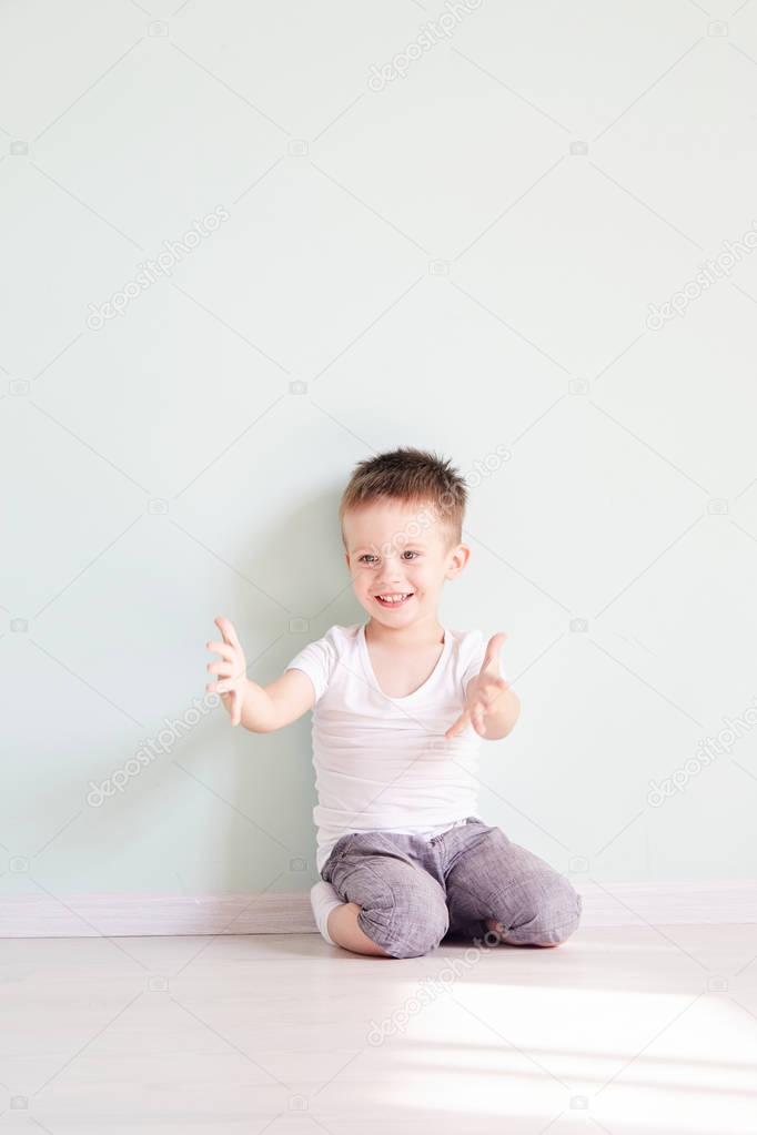Happy cute child reaching out his palms and catching something.