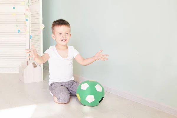 Retrato completo de un niño con una pelota de fútbol aislado en casa — Foto de Stock