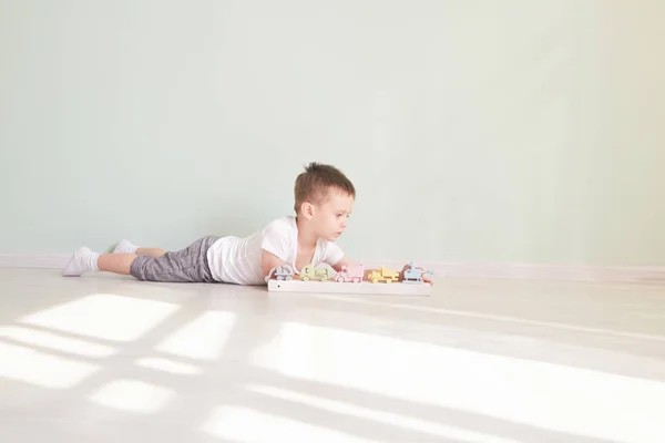 Pequeño niño juega con coche de juguete en casa — Foto de Stock