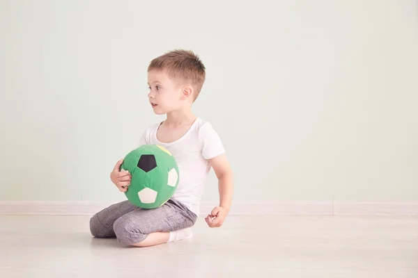 Tam uzunlukta portre olan bir çocuğun evde izole bir futbol topu — Stok fotoğraf