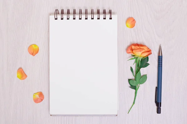 notebook paper, pen and purple dry flowers on white background. white blank notebook and pencil and rose