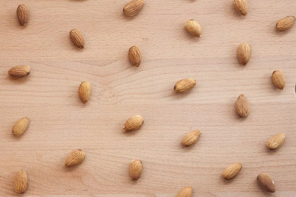 Badem beyaz bir arka plan veya düz ahşap bir masa. Kadın ellerinize badem.