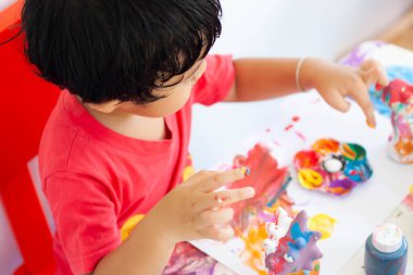 Suluboya ile oynayan çocuklar evde kalır. Küçük çocuk ve sulu boya.