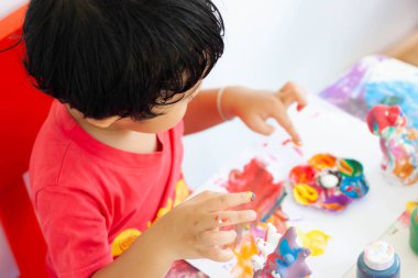Suluboya ile oynayan çocuklar evde kalır. Küçük çocuk ve sulu boya.