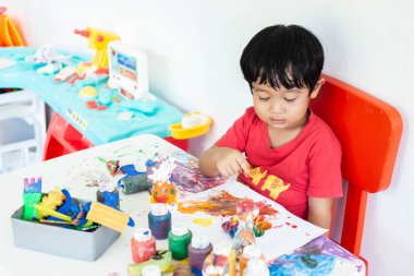 Suluboya ile oynayan çocuklar evde kalır. Küçük çocuk ve sulu boya.