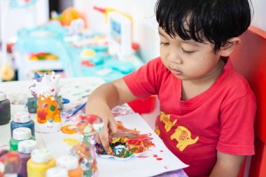 Suluboya ile oynayan çocuklar evde kalır. Küçük çocuk ve sulu boya.