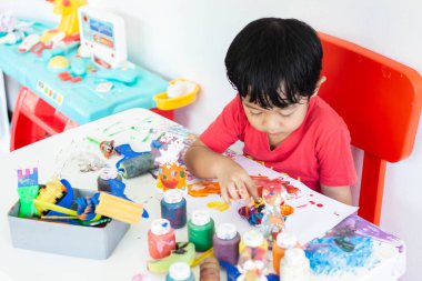 Suluboya ile oynayan çocuklar evde kalır. Küçük çocuk ve sulu boya.