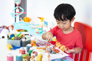 Suluboya ile oynayan çocuklar evde kalır. Küçük çocuk ve sulu boya.