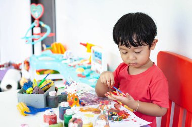 Suluboya ile oynayan çocuklar evde kalır. Küçük çocuk ve sulu boya.