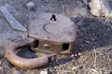 Paslı eski kapı kilidi, yerde yarı açık yatıyor, ama ev için kullanılabilir..