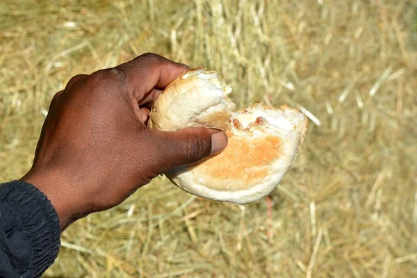 Левая Черная Рука Южноафриканского Голодного Мужчины Булочкой Белого Хлеба Которую — стоковое фото