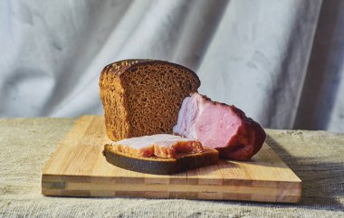 Çavdar unu ve pastırma bir kesme tahtası üzerinde bir parça ekmek