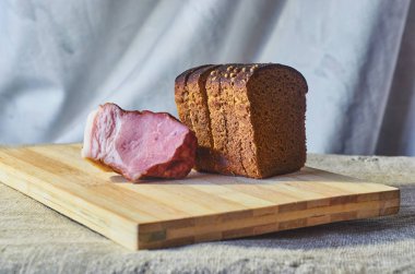 Çavdar unu ve pastırma bir kesme tahtası üzerinde bir parça ekmek