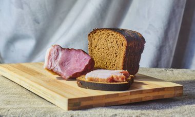 Çavdar unu ve pastırma bir kesme tahtası üzerinde bir parça ekmek