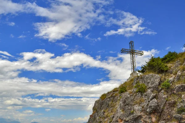 Cruz en la montaña con el cielo azul nublado en el fondo — Foto de Stock
