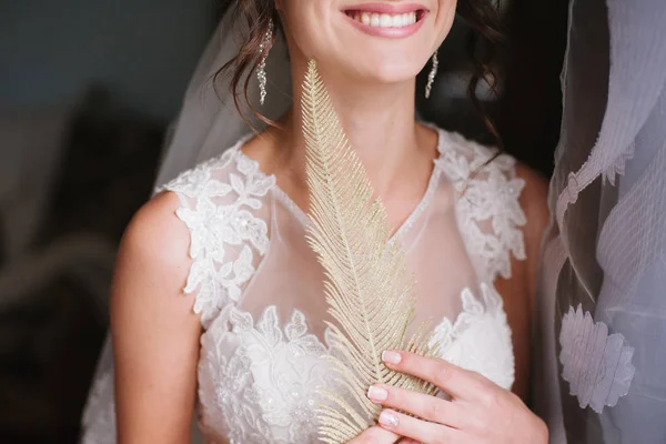Beautiful decoration. Golden feathers. Gold obrruchka. jewelry The bride in a white dress smiles — Stock Photo, Image
