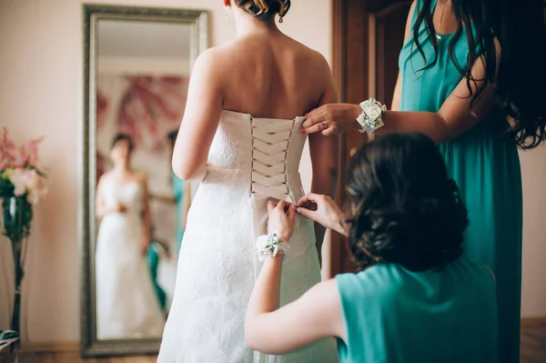 Meninas morenas ajudar a amarrar vestido de casamento branco — Fotografia de Stock