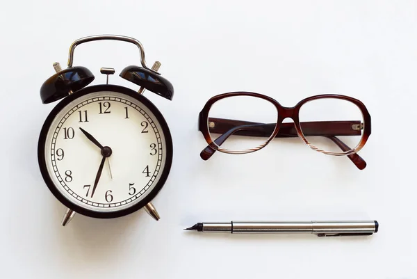 Klasický stolní hodiny pero, brýle na bílém pozadí. — Stock fotografie