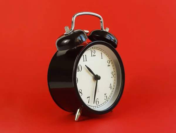 Κλασικό επιτραπέζιο ρολόι σε κόκκινο φόντο. — Φωτογραφία Αρχείου
