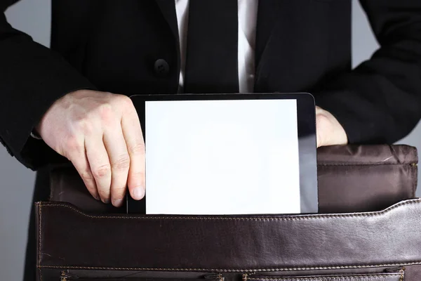Poner la tableta en una bolsa de gente de negocios . — Foto de Stock