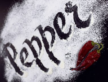 Un üzerinde yazıt. Biber. Siyah arka plan