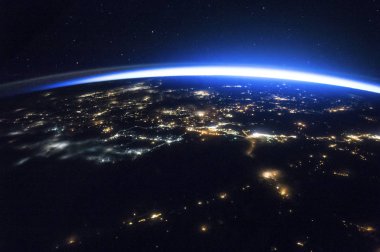 Işıl ışıl şehirlerin gece görüntüsü ve kuzey yarımküreyi çevreleyen gün ışığı. Bu görüntünün unsurları Nasa tarafından desteklenmektedir.