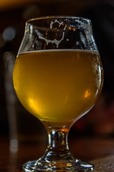 Крупный план бокала пива в помещении с солнечным светом — стоковое фото